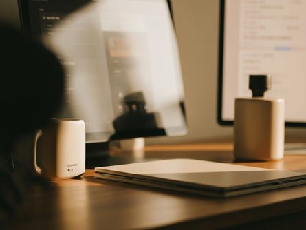 햇살이 드는 카페 창가에 놓인 크림 라떼와 크로와상, 흐릿한 가로수길 거리 배경